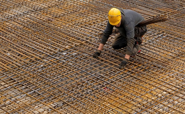 Construction worker laying rebar reinforcement on a building site